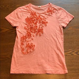 Short sleeve shirt with pink ruffle flowers.